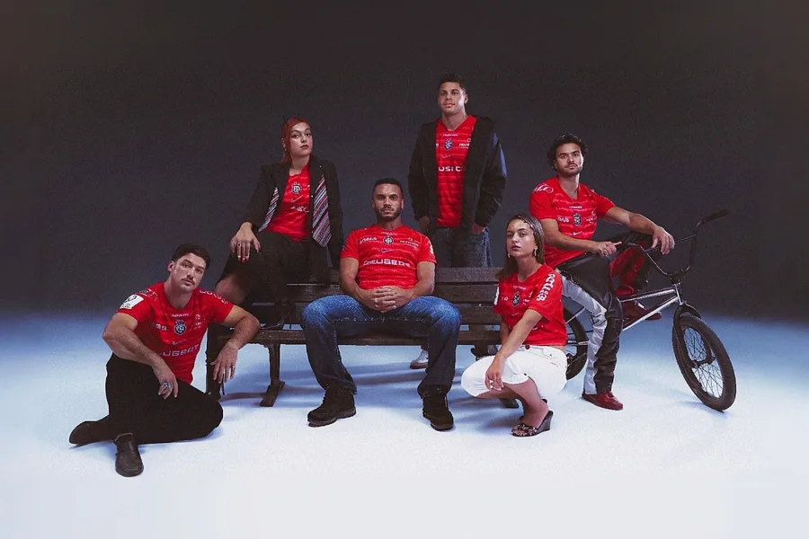 Six personnes portant le maillot européen rouge du Stade Toulousain 2026-2027